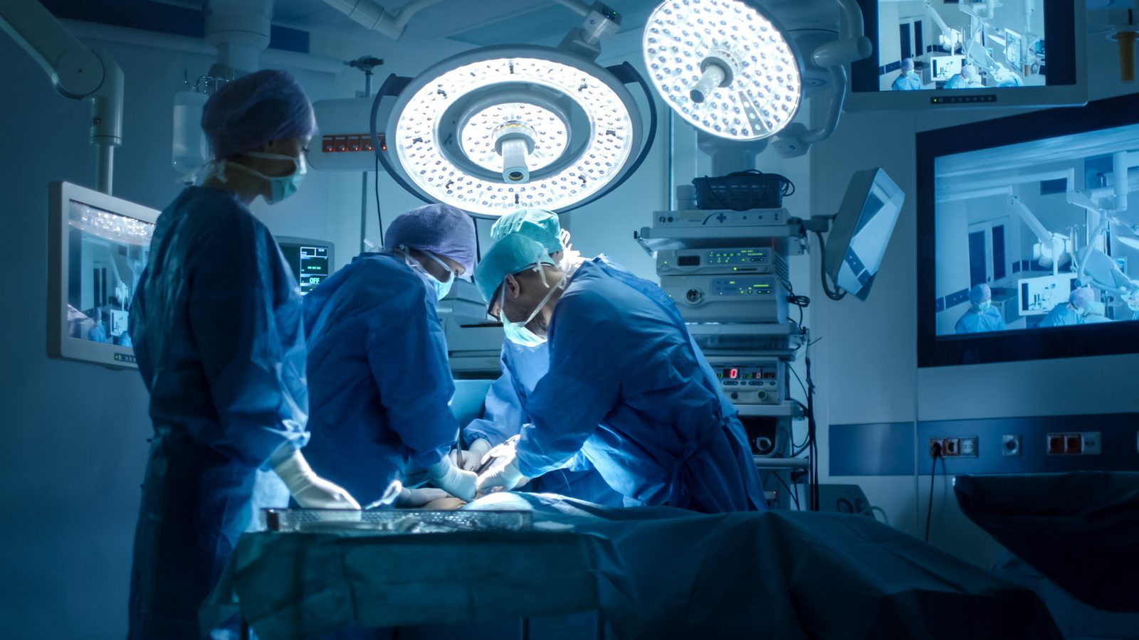 Surgical team operating under lights in a modern operating room